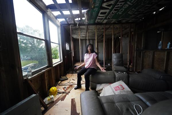 Louise Billiot, a member of the United Houma Nation Indian tribe, talks inside the home of her friend Irene Verdin, which was heavily damaged from Hurricane Ida nine months before, along Bayou Pointe-au-Chien, La., Thursday, May 26, 2022. (AP Photo/Gerald Herbert)