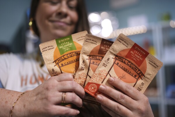 Employee Savannah Gavlik displays THC products at the Dope Daughters dispensary that Texas lawmakers are seeking to ban, Thursday, May 29, 2025, in Austin, Texas. (AP Photo/Eric Gay)