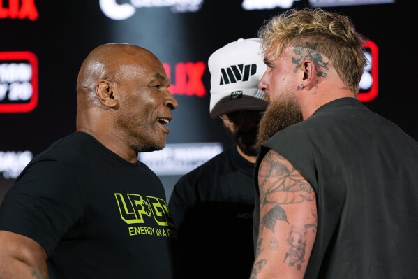 FILE - Mike Tyson, left, and Jake Paul, right, face off during a news conference promoting their upcoming boxing bout, May 16, 2024, in Arlington, Texas. (AP Photo/Sam Hodde, File)