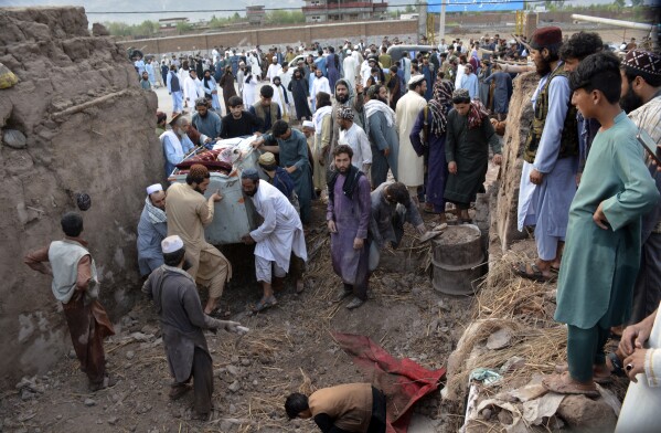People gather to clear the rubble of a house partially damaged by landslide due to heavy rainfall in Surkhroad district of Jalalabad, Nangarhar province east of Kabul, Afghanistan, Monday, July 15, 2024. (AP Photo/Shafiullah Kakar)