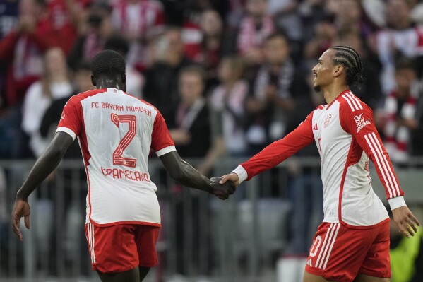 Bayern's Leroy Sane, right, celebrates with team mate Bayern's Dayot Upamecano after scoring his side's second goal during the German Bundesliga soccer match between FC Bayern Munich and SC Freiburg at the Allianz Arena stadium in Munich, Germany, Oct. 8, 2023. (AP Photo/Matthias Schrader)