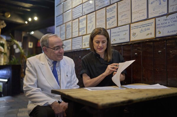 Irene Guinales, right, and Pedro Guinales del Valle, owners and managers of Casa Pedro restaurant, review documents regarding the restaurant's opening date in Madrid, Spain, on May 16, 2025. (AP Photo/Manu Fernandez)