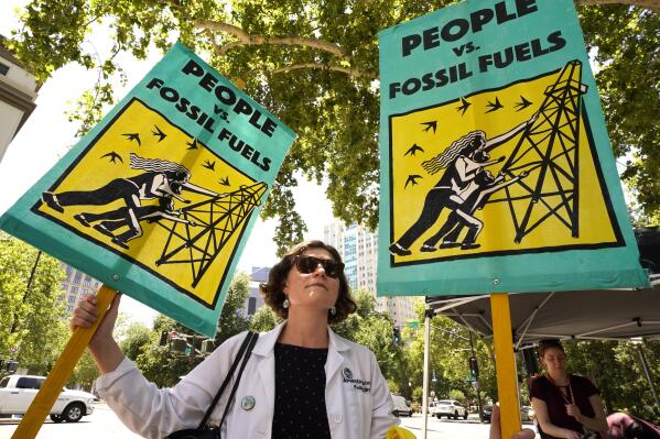 Pediatrician Amanda Millstein, joins with other climate activists demonstrating outside a hearing of the California Air Resources Board in Sacramento, Calif., Thursday, June 23, 2022. The board was taking public testimony on a plan that outlines how the state will achieve carbon neutrality by 2045.(AP Photo/Rich Pedroncelli)