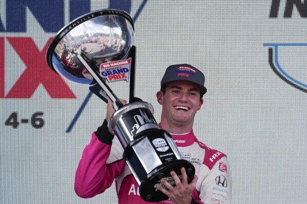Kyle Kirkwood holds the trophy winning the Music City Grand Prix auto race Sunday, Aug. 6, 2023, in Nashville, Tenn. (AP Photo/George Walker IV)