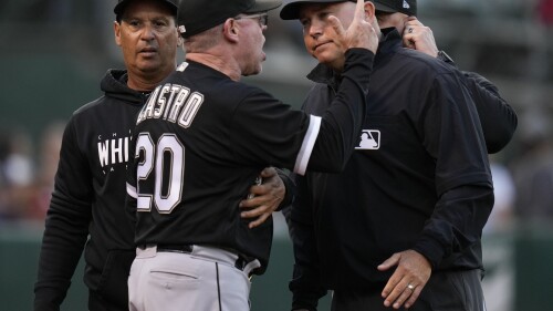 Chicago White Sox hitting coach José Castro (20) speaks to first base umpire Mark Carlson, right, after he was ejected by home plate umpire Tripp Gibson at the end of the fourth inning of a baseball game against the Oakland Athletics in Oakland, Calif., Friday, June 30, 2023. (AP Photo/Godofredo A. Vásquez)