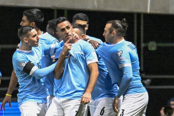 Israel's Eran Zahavi celebrates with teammates after scoring his side's opening goal during the Euro 2024 group I qualifying soccer match between Israel and Romania at the Pancho Arena in Felcsut, Hungary, Saturday, Nov. 18, 2023. (AP Photo/Denes Erdos)