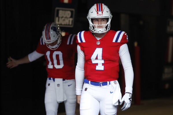 New England Patriots quarterback Bailey Zappe (4), followed by quarterback Mac Jones (10) walks onto the field prior to an NFL football game against the Los Angeles Chargers, Sunday, Dec. 3, 2023, in Foxborough, Mass. (APPhoto/Michael Dwyer)