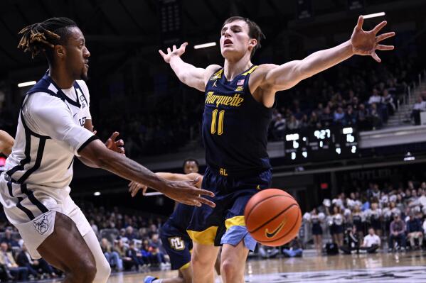 Butler center Manny Bates passes the ball around Marquette guard Tyler Kolek (11) during the first half of an NCAA basketball game, Tuesday, Feb. 28, 2023, in Indianapolis. (AP Photo/Marc Lebryk)
