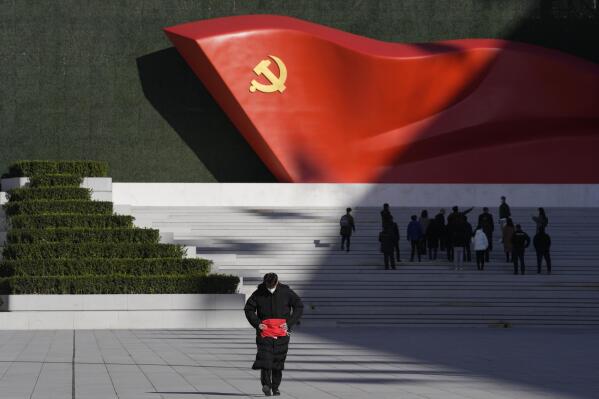 A worker folds a flag near a sculpture of the Chinese Communist Party flag outside the Museum of the Communist Party of China here in Beijing, China, Friday, Nov. 12, 2021. Chinese leader Xi Jinping emerges from a party conclave this week not only more firmly ensconced in power than ever, but also with a stronger ideological and theoretical grasp on the ruling Communist Party's past, present and future. (AP Photo/Ng Han Guan)