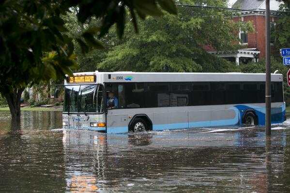 A bus drives through flooding in the Ghent neighborhood of Norfolk, Va., after heavy rainfall on Aug. 11, 2020. The increasing threat of sea-level rise on Virginia’s coast means that an afternoon rainstorm can strand drivers for hours and damage cars beyond repair. The city of Norfolk is trying to do something about that. Officials have partnered with the tech firm FloodMapp and the Waze traffic app to warn residents of flooded roadways in real time. (Kristen Zeis/The Virginian-Pilot via AP)