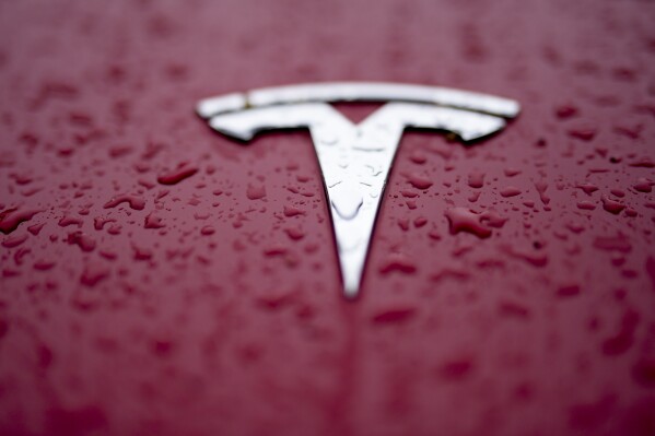 FILE - A Tesla logo is shown on Feb. 27, 2024, in Charlotte, N.C. A Tesla apparently operating on one of the company's automated driving systems crashed into a parked police vehicle Thursday, June 13, 2024, near Los Angeles, narrowly missing an officer who was managing traffic at another crash. (AP Photo/Chris Carlson, File)