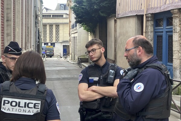 French policemen stand the synagogue in Rouen, France, Friday, May 17, 2024. French police have shot and killed a man armed with a knife and a metal bar who is suspected of having set fire to a synagogue in the Normandy city of Rouen. (AP Photo/Oleg Cetinic)