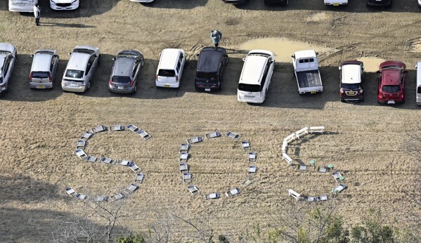 SOS letters formed by folding chairs are seen at a schoolyard after the strong earthquake in Suzu, Ishikawa prefecture, Japan, Jan. 2, 2024. (Kyodo News via AP)