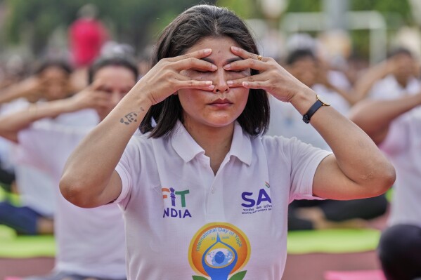 Indians perform yoga during an event to mark International Day of Yoga at a playground in Guwahati, India, Saturday, June 21, 2025. (AP Photo/Anupam Nath)