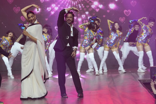FILE - Bollywood actors Deepika Padukone, left, and Shah Rukh Khan, right, dance at an event to celebrate the success of their movie "Jawan" in Mumbai, India, on Sep. 15, 2023. India’s Hindi language movie industry, Bollywood, made an impressive financial recovery in 2023 after a pandemic-driven slowdown, audience fatigue with big studio productions and Bollywood megastars, and streaming platforms taking away a big chunk of viewership. (AP Photo/Rajanish Kakade, File)