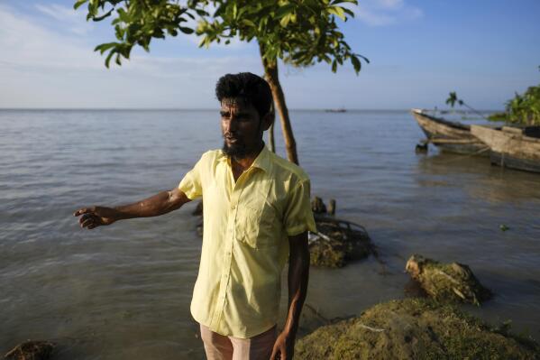 Mohammad Jewel stands on his land which was lost due to river erosion in Elisha Ghat area in Bhola, Bangladesh on July 4, 2022. Jewel and Arzu Begum were forced to flee last year when the Meghna River flooded and destroyed their home. (AP Photo/Mahmud Hossain Opu)