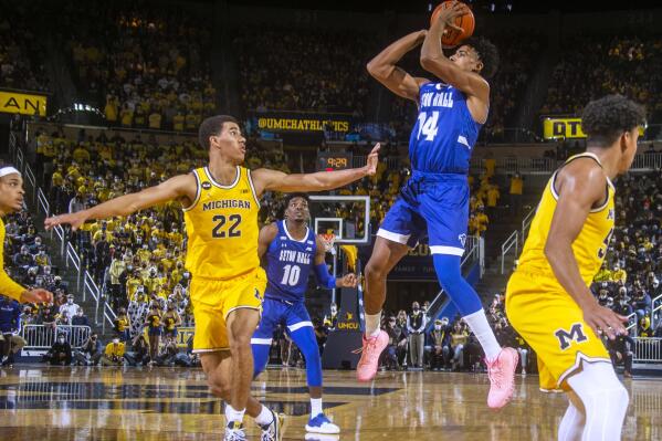 Michigan guard Caleb Houstan (22) defends against a jump shot from Seton Hall guard Jared Rhoden (14) during the first half of an NCAA college basketball game in Ann Arbor, Mich., Tuesday, Nov. 16, 2021. (AP Photo/Tony Ding)
