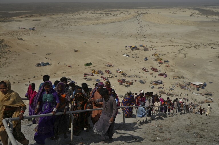 Hindu devotees climb stairs to reach atop a volcano to start Hindu pilgrims' religious rituals for an annual festival in an ancient cave temple of Hinglaj Mata in Hinglaj in Lasbela district in Pakistan's southwestern Baluchistan province, Friday, April 26, 2024. More than 100,000 Hindus are expected to climb mud volcanoes and steep rocks in southwestern Pakistan as part of a three-day pilgrimage to one of the faith's holiest sites. (AP Photo/Junaid Ahmed)