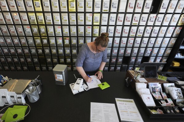 Owner Lisa McDonald packages loose leaf tea orders at the TeaHaus Thursday, April 24, 2025, in Ann Arbor, Mich. (AP Photo/Paul Sancya)