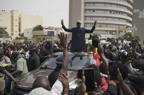 The opposition leader Ousmane Sonko greets his supporters after leaving the tribunal, in Dakar, Senegal, Thursday, Feb. 16, 2023. Police in Senegal smashed out the windows of Sonko's car and forced him from the vehicle after he appeared in court. (AP Photo/Leo Correa)