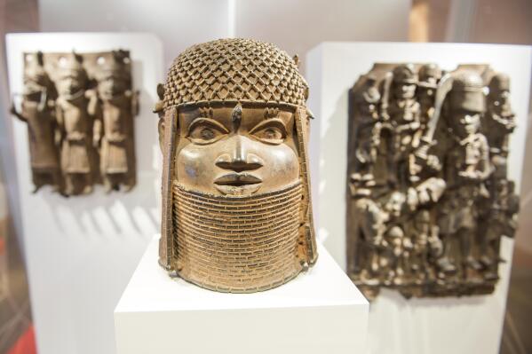 Three pieces of Benin Bronzes are displayed at Museum for Art and Crafts in Hamburg, Germany, Wednesday, Feb. 14, 2018. Germany is returning hundreds of artifacts known as Benin Bronzes that were mostly looted from western Africa by a British colonial expedition and subsequently sold to collections around the world, including German museums. (Daniel Bockwoldt/dpa via AP)