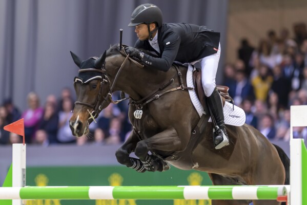 FILE - Kent Farrington, from the United States, rides his horse Holst, to win the first place of the 19th top 10 IJRC at the 59th CHI international horse show jumping tournament in Geneva, Switzerland, Friday, Dec. 13, 2019. (Martial Trezzini/Keystone via AP, File)