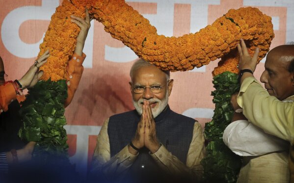 
              Indian Prime Minister Narendra Modi receives a giant floral garland from party leaders at their headquarters in New Delhi, India, Thursday, May 23, 2019. Indian Prime Minister Narendra Modi's party claimed it had won reelection with a commanding lead in Thursday's vote count, while the stock market soared in anticipation of another five-year term for the pro-business Hindu nationalist leader. (AP Photo/Manish Swarup)
            