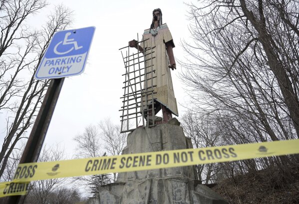 Police tape surrounds the Skowhegan Indian statue in Skowhegan, Maine on Tuesday March 5, 2024. The 62-foot-tall sculpture is currently missing an arm and part of its face, and it's believed to be due to the effects of the weather and a windstorm that left part of its face, an arm and a spear missing. (Rich Abrahamson /The Central Maine Morning Sentinel via AP)