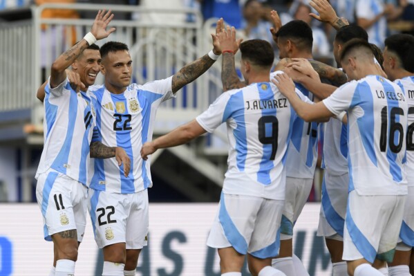 CORRECTS TO ÁNGEL DI MARÍA NOT ANGEL CORREA - Argentina's Ángel Di María (11) celebrates with teammates after scoring during the first half of an international friendly soccer match against Ecuador, Sunday, June 9, 2024, in Chicago. (AP Photo/Paul Beaty)