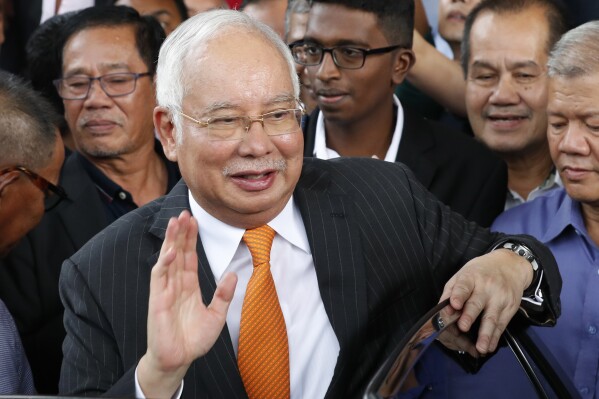 FILE - Former Malaysian Prime Minister Najib Razak waves as he leaves Kuala Lumpur High Court in Kuala Lumpur, Malaysia, Nov. 11, 2019. Malaysia's Pardons Board said Friday, Feb. 2, 2024, it has reduced ex-Prime Minister Najib Razak's 12-year jail sentence by half and sharply cut the fine imposed after his corruption conviction.(AP Photo/Vincent Thian, File)