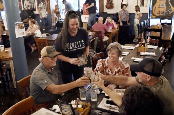 FILE - Macy Norman, center, serves a table of guests at Puckett's Grocery and Restaurant, on Sept. 10, 2021, in Nashville, Tenn. The net worth of the typical U.S. household grew at the fastest pace in more than three decades from 2019 through 2022, while low interest rates made it easier for households to pay their debts, according to a government report Wednesday. (AP Photo/Mark Humphrey, File)
