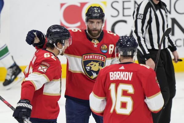 Florida Panthers defenseman Aaron Ekblad (5) celebrates after scoring with defenseman Brandon Montour (62) and center Aleksander Barkov (16) during the second period of an NHL hockey game against the Vancouver Canucks, Saturday, Jan. 14, 2023, in Sunrise, Fla. (AP Photo/Wilfredo Lee)