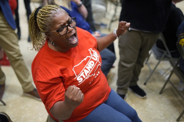 Volkswagen automobile plant employee Vicky Holloway celebrates as she watches the results of a UAW union vote, late Friday, April 19, 2024, in Chattanooga, Tenn. (AP Photo/George Walker IV)