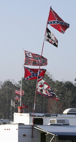 FILE - In this March 18, 2005, file photo, Confederate stars and bars flags fly on = poles attached to campers at Atlanta Motor Speedway in Hampton, Ga. NASCAR has a checkered racial history, from a long-time affinity for Confederate flags among the fan base to a driver losing his job just this season for casually uttering a racial epitaph.(AP Photo/Ric Feld, File)