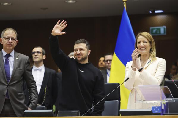 Ukraine's President Volodymyr Zelenskyy, centre, gestures as European Parliament's President Roberta Metsola, right, applauds during an EU summit at the European Parliament in Brussels, Belgium, Thursday, Feb. 9, 2023. On Thursday, Zelenskyy will join EU leaders at a summit in Brussels, which German Chancellor Olaf Scholz described as a "signal of European solidarity and community." (AP Photo/Olivier Matthys)