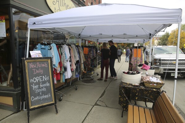 Shoppers stop at a sidewalk sale at Althea's Attic Boutique in Montpelier, Vt., on Friday, Oct. 6, 2023. Three months after flooding inundated the small city, Montpelier is holding a reopening celebration on Friday and Saturday to show the progress. (AP Photo/Lisa Rathke)