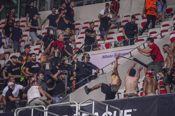Nice supporters, bottom left, clash with FC Koln supporters, right, prior to the start of the Europa Conference League Group D match between OCG Nice and FC Koln at the Allianz Riviera stadium in Nice, France, Thursday, Sept. 8, 2022. (AP Photo/Daniel Cole)