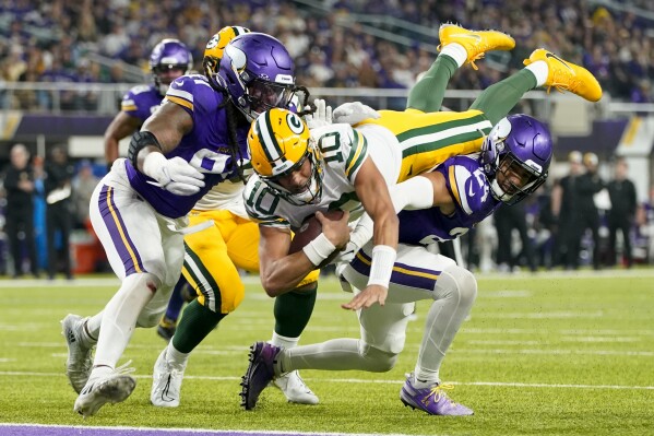 Green Bay Packers' Jordan Love dives into the end zone for a touchdown during the first half of an NFL football game against the Minnesota Vikings Sunday, Dec. 31, 2023, in Minneapolis. (AP Photo/Abbie Parr)