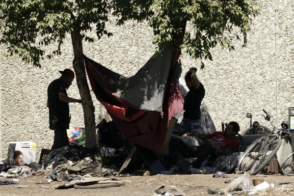 FILE - A homeless encampment is shaded by a tree in Sacramento, Calif., on Aug. 12, 2022. A federal judge in the U.S. District Court for Eastern California in early Aug. 2023, ordered Sacramento to temporarily stop clearing homeless encampments for 14 days due to excessive heat. (AP Photo/Rich Pedroncelli, File)