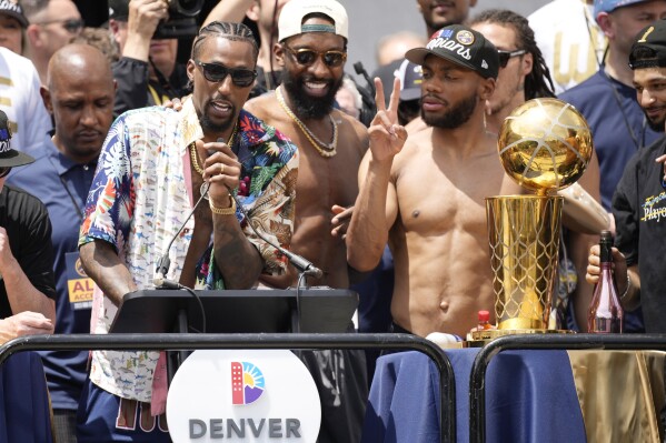 Denver Nuggets guard Kentavious Caldwell-Pope, and forward Bruce Brown celebrate during a rally and parade to mark the team's first NBA basketball championship on Thursday, June 15, 2023, in Denver. (AP Photo/David Zalubowski)