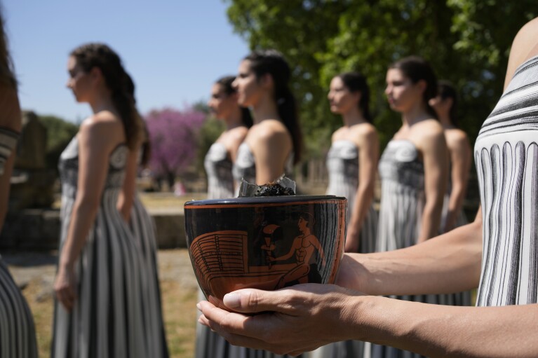 A performer holds the new ceramic pot, that will be used at the lighting ceremony for the Paris Olympics, during a rehearsal at Ancient Olympia site, Greece, Sunday, April 14, 2024. Every two years, a countdown to the Olympic games is launched from its ancient birthplace with a flame lighting ceremony in southern Greece at Ancient Olympia. The event is marked with a performance by dancers who assume the role of priestesses and male companions, their movement inspired by scenes on millennia-old artwork. (AP Photo/Thanassis Stavrakis)
