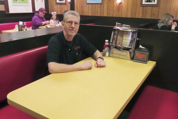 Ron Stark, co-owner of Holsten's, the Bloomfield N.J. ice cream parlor and restaurant where the final scene of "The Sopranos" TV series was filmed, sits on March 5, 2024, at a recreation of the booth where Tony Soprano may or may not have met his end. The day before, the original booth used in the show was was sold in an online auction for $82,600 to a buyer that wishes to remain anonymous. (AP Photo/Wayne Parry)