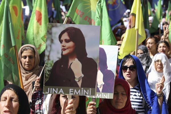 In this photo provided by Kurdish-run Hawar News Agency, Kurdish women hold portraits of Iranian Mahsa Amini, during a protest condemning her death in Iran, in the city of Qamishli, northern Syria, Monday, Sept. 26, 2022. Protests have erupted across Iran in recent days after Amini, a 22-year-old woman, died while being held by the Iranian morality police for violating the country's strictly enforced Islamic dress code. (Hawar News Agency via AP via AP)