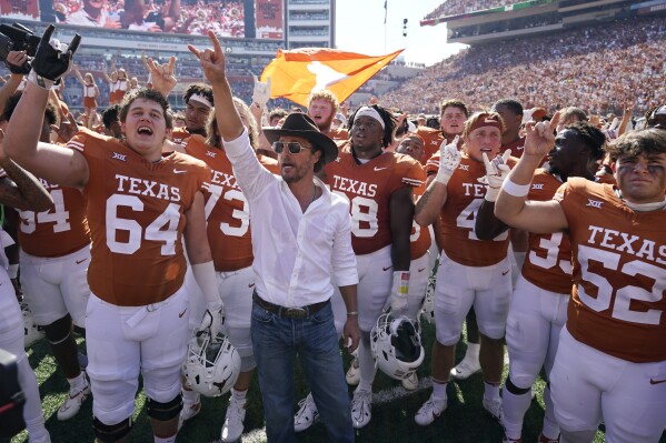 Actor Matthew McConaughey, center, celebrates with Texas players after their win over Kansas State in overtime of an NCAA college football game in Austin, Texas, Saturday, Nov. 4, 2023. (AP Photo/Eric Gay)