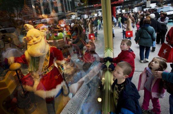 FILE - Garrett Folts, 7, left, looks at a Macy's Santa Claus window display with his brother Cameron, 9, center and sister Chloe, 5, while shopping with their mother, Nov. 21, 2007 in New York. Macy's said Santa Claus won't be greeting kids at its flagship New York store this year due to the coronavirus, interrupting a holiday tradition started nearly 160 years ago. However, Macy's said the jolly old man will still appear at the end of the televised Macy's Thanksgiving Day parade. (AP Photo/Mark Lennihan, File)
