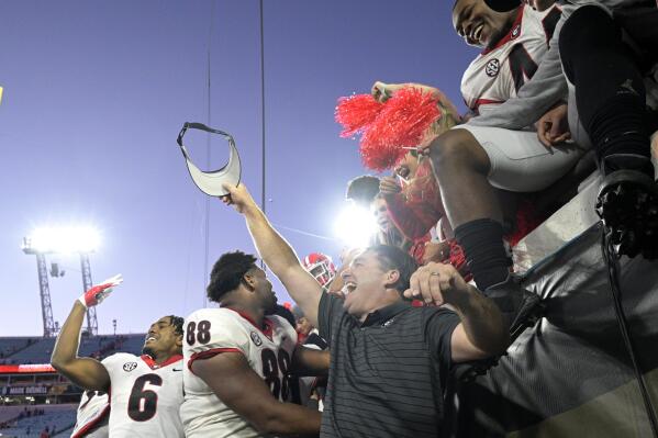Georgia head coach Kirby Smart, center, celebrates with players and fans in the stands after they defeated Florida in an NCAA college football game, Saturday, Oct. 30, 2021, in Jacksonville, Fla. (AP Photo/Phelan M. Ebenhack)