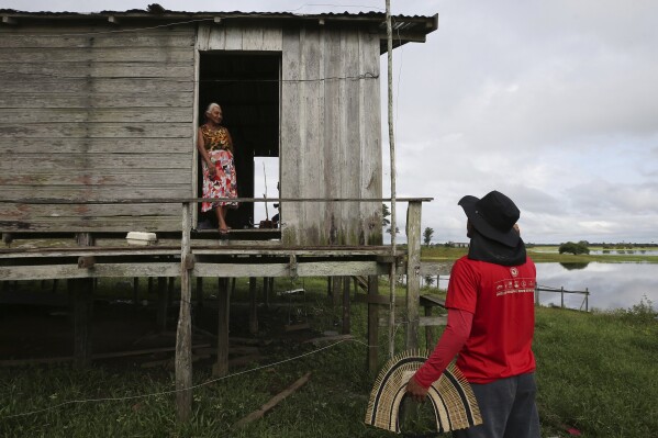 Indigenous leader Filipe Gabriel Mura talks with his aunt in the Lago do Soares village in Autazes, Amazonas state, Brazil, Feb. 18, 2025. (AP Photo/Edmar Barros)