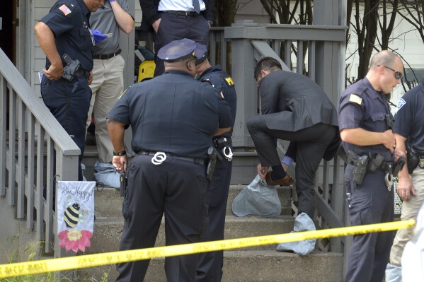 Hampden District Attorney Anthony Gulluni puts on crime scene booties at the scene of a shooting with multiple victims a home in Springfield, Mass., Monday, Aug. 14, 2023. A 10-year-old girl shot by a neighbor who forced his way into her family's apartment earlier this week has died, authorities and her mother said, Thursday, Aug. 17. (Don Treeger/The Republican via AP)