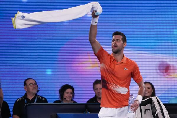 Serbia's Novak Djokovic swings his towel as he dances between games during an exhibition match against Australia's Nick Kyrgios on Rod Laver Arena ahead of the Australian Open tennis championship in Melbourne, Australia, Friday, Jan. 13, 2023. (AP Photo/Mark Baker)