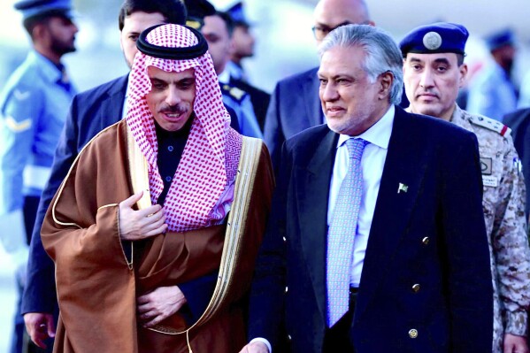 In this photo released by Ministry of Foreign Affairs, Pakistani's Foreign Minister Ishaq Dar, right, greets his Saudi counterpart Prince Faisal bin Farhan upon his arrival at a military airbase in Rawalpindi, Pakistan, Monday, April 15, 2024. Saudi Arabia's foreign minister led a high-level delegation on a two-day visit to Pakistan, which is seeking help in overcoming one of its worst economic crises. (Ministry of Foreign Affairs via AP)